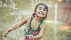 Girl plays in splash park - find joy this summer at one of these splash parks near East London