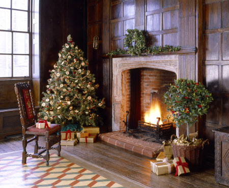 A delightful traditional Christmas scene at Sutton House showing a beautifully decorated tree, gifts and open log fire.