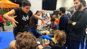 Scientist animatedly discusses the Megaladon tooth fossils enrapturing children at New Scientist Live. London Mum review by Chloe Tyler