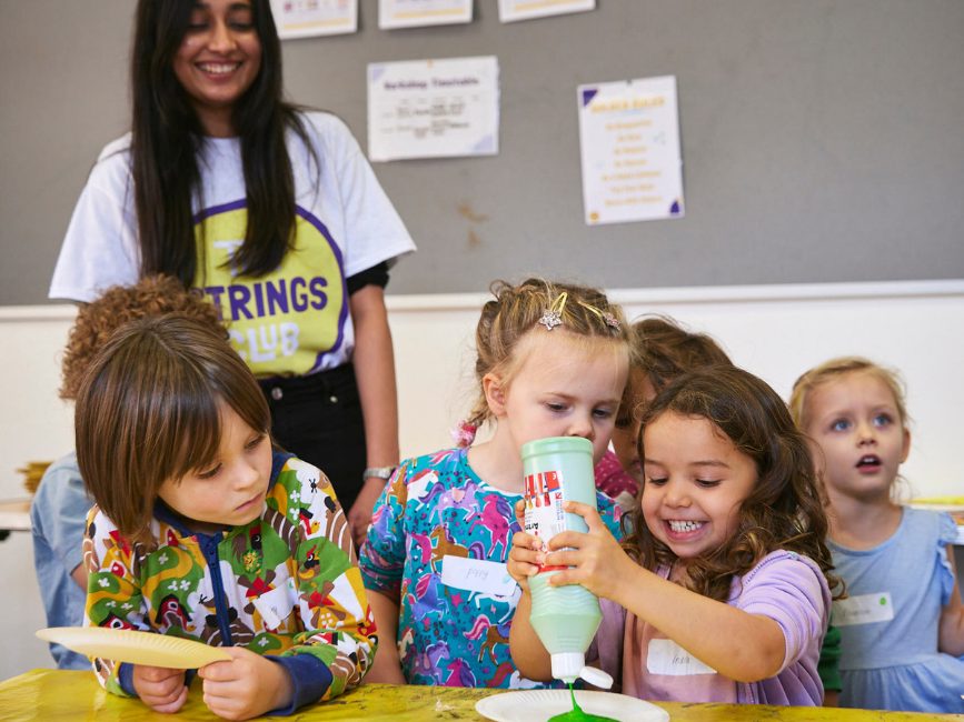 Children play with green paint at The Strings Club Holiday Camps in Eat London