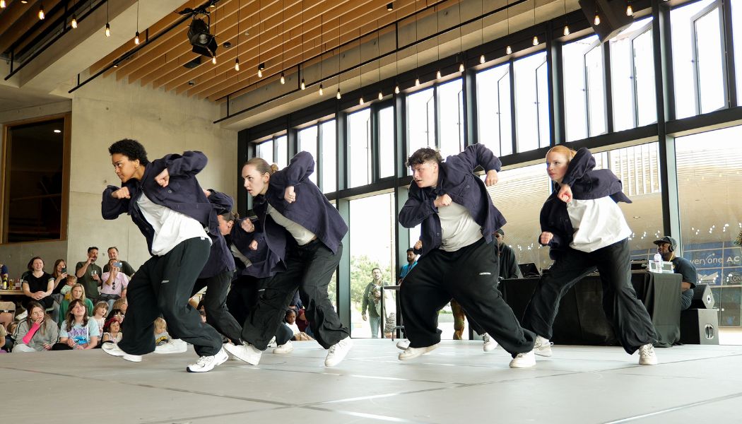 Breakin Convention hip hop dancers dressed in black and white streetwear perform for families at Sadler's Wells East